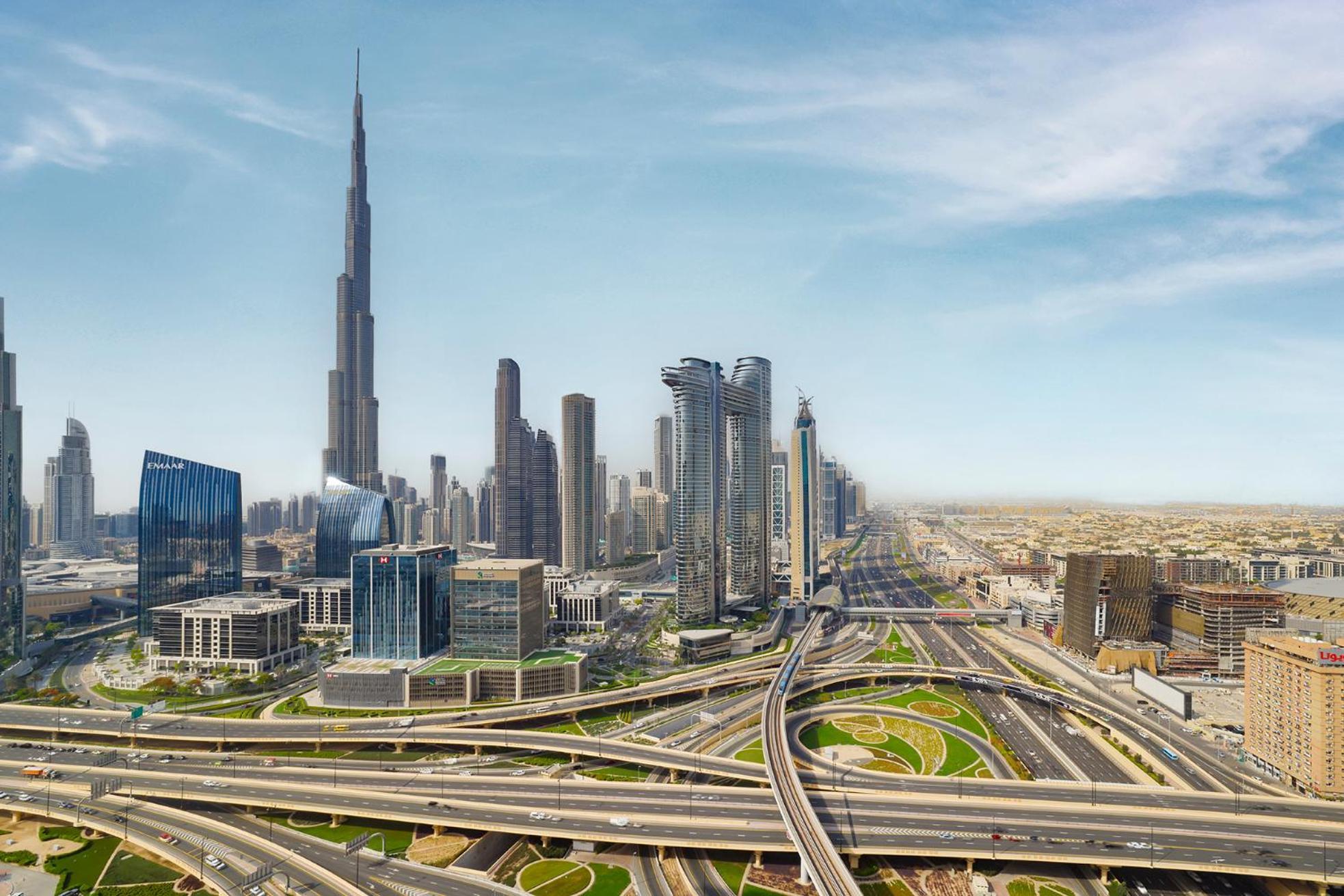 Dusit Thani Dubai Exterior photo The photo showcases a modern city skyline, prominently featuring the Burj Khalifa, the tallest building in the world. Surrounding it are various high-rise buildings with sleek architectural designs, reflecting the city's contemporary style. The image